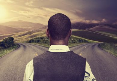 Young man standing at crossroads