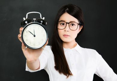 Young woman holding old alarm clock