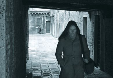 Young woman walking through archway, Venice, Italy