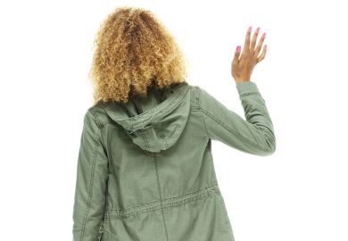 Young woman waving away from camera