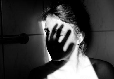 Young woman with shadow of hand over face Young woman with shadow of hand over face