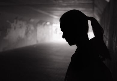 Young female standing in a dark tunnel