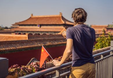 Young man with national chinese flag in Forbidden City