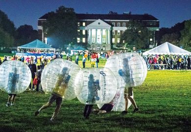 People in plastic bubbles play on a field