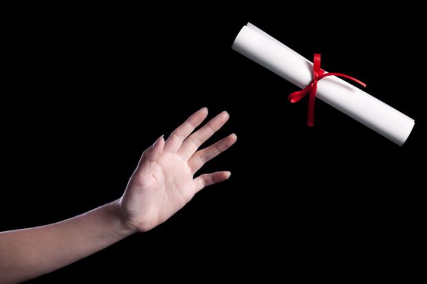 A hand reaching out to take a rolled up copy of a degree certificate A hand reaching out to take a rolled up copy of a degree certificate