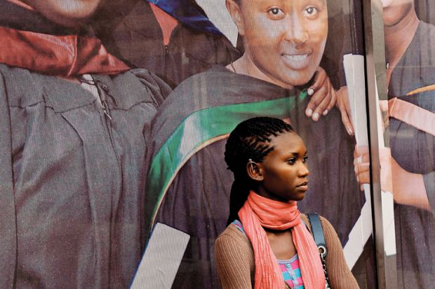 African woman standing in front of university sign African woman standing in front of university sign
