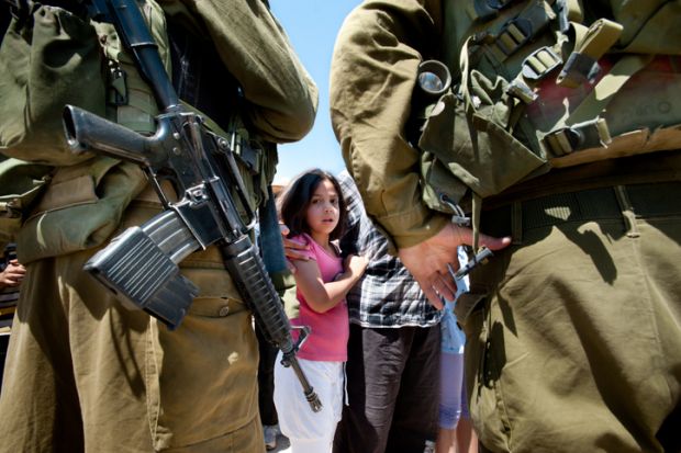 Al-Walaja, Occupied Palestinian Territories - August 27, 2011 A Palestinian girl confronts Israeli soldiers in a protest against the encirclement of the West Bank town of Al-Walaja by the Israeli separation barrier. Al-Walaja, Occupied Palestinian Territories - August 27, 2011 A Palestinian girl confronts Israeli soldiers in a protest against the encirclement of the West Bank town of Al-Walaja by the Israeli separation barrier.