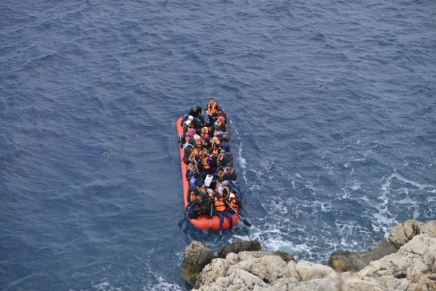 An inflatable boat filled with refugees and other migrants approaches the south coast of Turkey