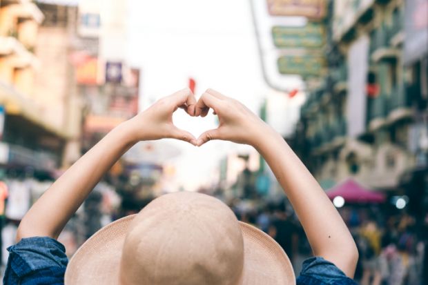 Asian traveller woman hand with heart gesture for love