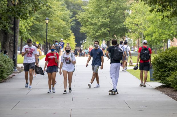 August 20, 2020 During the COVID-19 pandemic, students wear face coverings while walking on campus on the first day of the Fall semester at the University of Georgia.