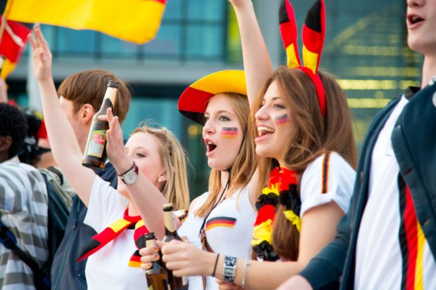 Berlin, Germany - June 13, 2012 Group of german soccer fans at the public viewing in berlin watching the football match.Cheering, celebrating, having fun together.