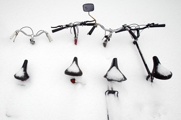 Bicycles are buried in snow in Montreal, Canada. To illustrate that the flow of international students to Canada is declining.