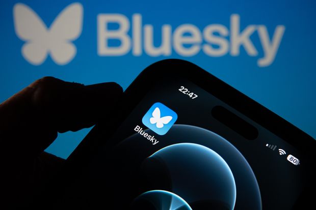 Photo illustration a smartphone screen displaying the logo of social media app Bluesky