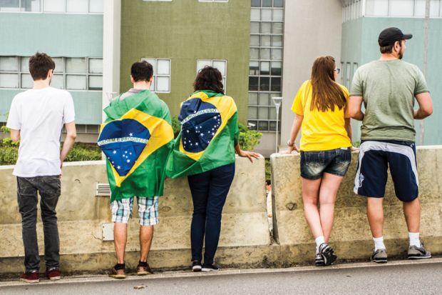 Brazilians with flags looking over wall Brazilians with flags looking over wall