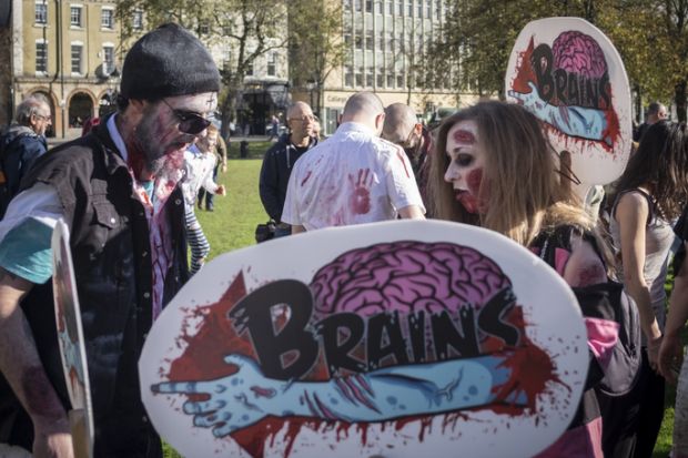 Bristol, United Kingdom - 28 October 2017 People dress up as zombies for the tenth Anniversary Bristol Zombie Walk and carry banners as part of halloween celebrations in Bristol, UK.