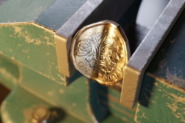 British pound coin held by a bench vice or clamp British pound coin held by a bench vice or clamp