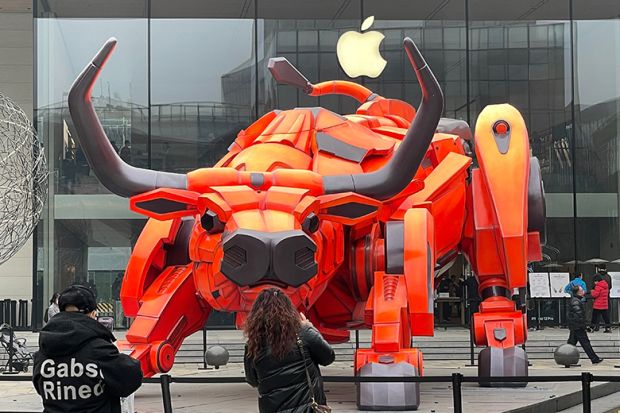 People look at a bull statue set up in front of an Apple store at Sanlitun, 2021 in Beijing, China. To illustrate if the academy can rein in Big Tech. People look at a bull statue set up in front of an Apple store at Sanlitun, 2021 in Beijing, China. To illustrate if the academy can rein in Big Tech.
