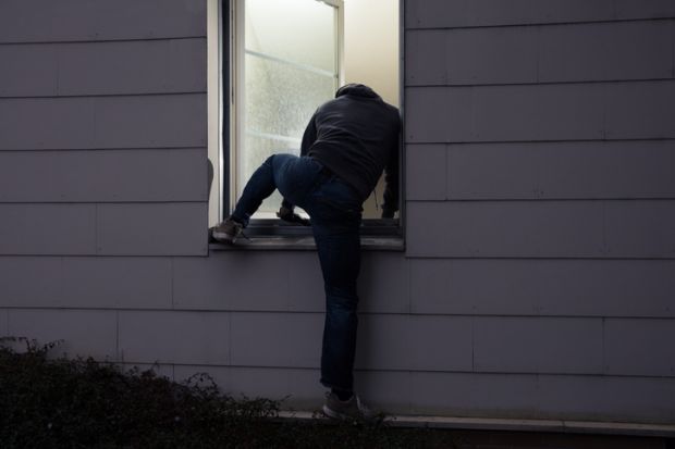 Burglar climbing in a window Burglar climbing in a window