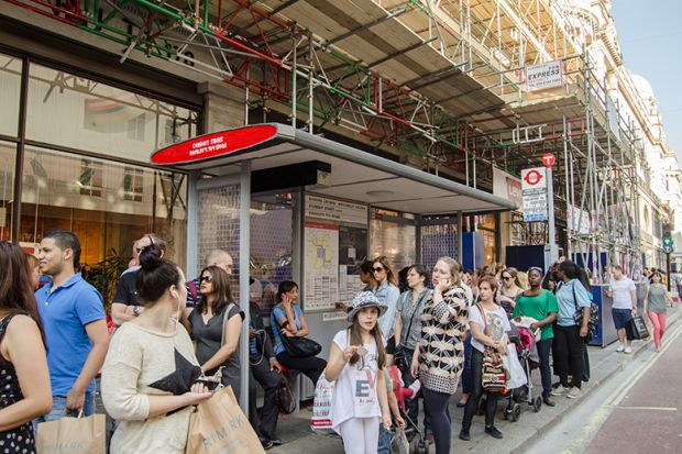People wait at a bus stop People wait at a bus stop