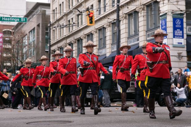 Vancouver, BC, Canada – November 11, 2016: RCMP officers, dressed in ceremonial red serge, march through downtown Vancouver for Remembrance Day.
