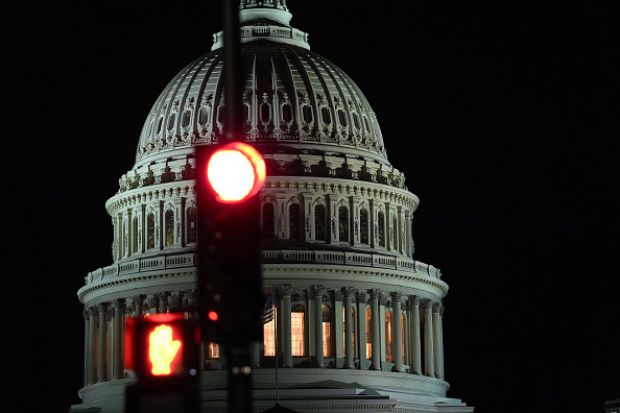 The US capitol building with a red traffic light in front of it, illustrating democracy under threat