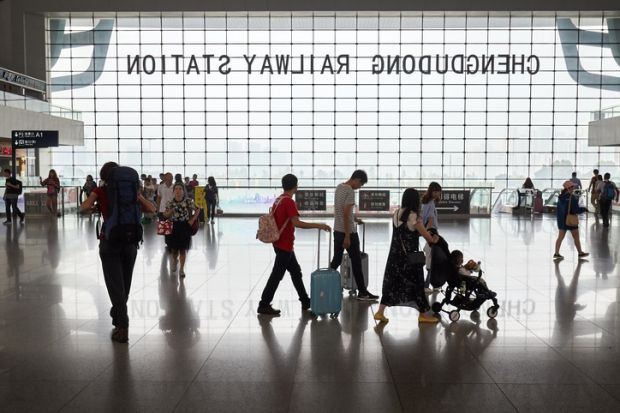 Chengdu, China - October 01, 2017 Passengers silhouettes inside the Chengdu railway station modern building.