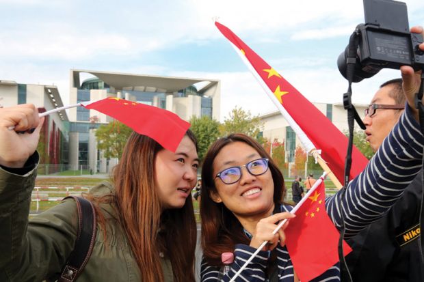 Two women take a selfie with Chinese flags Two women take a selfie with Chinese flags