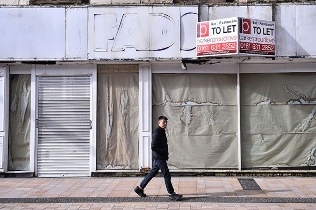 A man walks past a closed shop which is to let in Stockport, England. To illustrate that almost 4,000 courses have closed at UK universities since 2024.