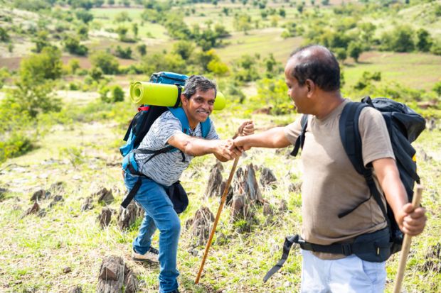 An Indian man helps another one up a hill An Indian man helps another one up a hill, symbolising collaboration to improve