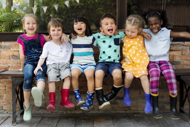 Children in wellington boots, arm in arm, representing collegiality Children in wellington boots, arm in arm, representing collegiality in higher education