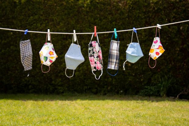 Colourful coronavirus masks in the garden hung up on a washing line