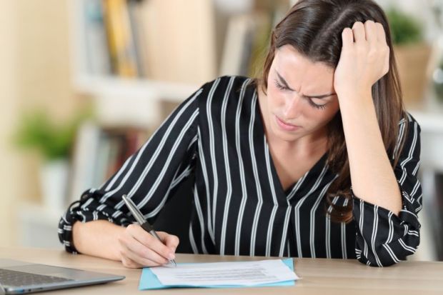 Concerned woman signs document Concerned woman signs document