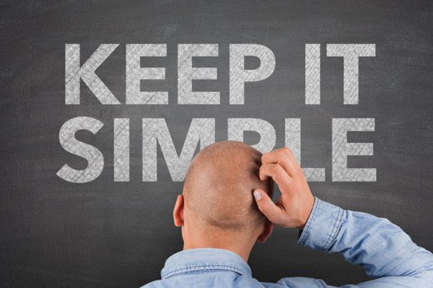 Confused man looking at 'Keep it simple' sign Confused man looking at 'Keep it simple' sign