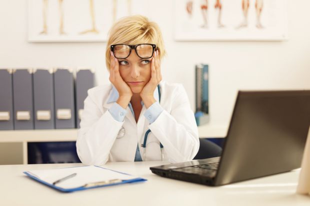 A doctor looking confused at her desk