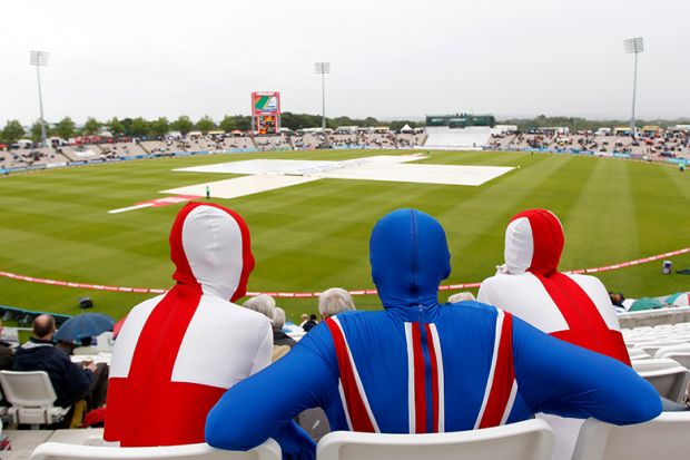 Spectators in England and Union Jack costumes wait as rain delays play a cricket match between England and Sri Lanka. To illustrate extending the path to UK citizenship to more than 10 years could deter international researchers from settling in the UK.