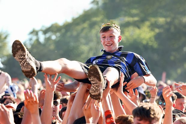  A music fan wearing a crown crowd surfs at the TRNSMT Festival. To illustrate academic communities in all parts of the UK helping rising stars of humanities and social sciences to shine.