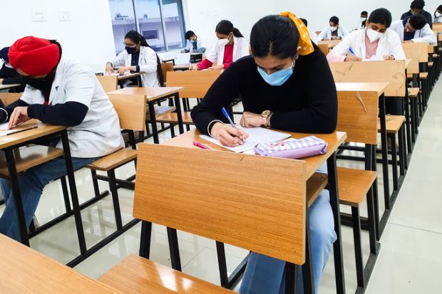 December 8, 2020.Lucknow Uttar Pradesh,India. West Bengal India. Medical students writing examination paper in mask maintaining social distancing at Radheshwam Medical College,Lucknow, UP, India.