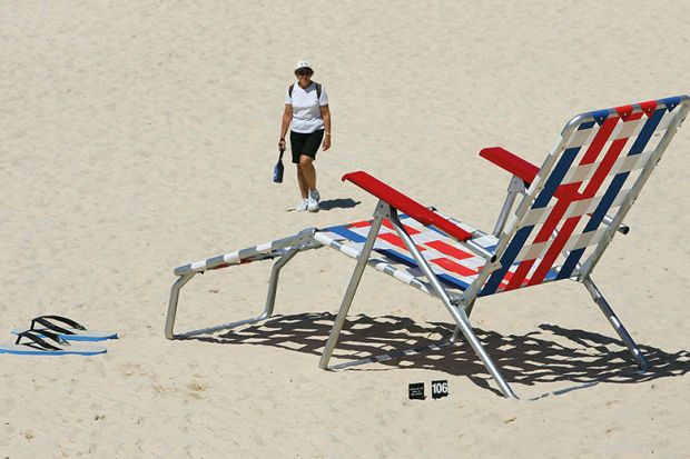 Woman walks near an oversized deckchair artwork ’Recliner Rex’ by New Zealand artist Regan Gentry on Tamarama Beach in Sydney, 2005 Woman walks near an oversized deckchair artwork ’Recliner Rex’ by New Zealand artist Regan Gentry on Tamarama Beach in Sydney, 2005