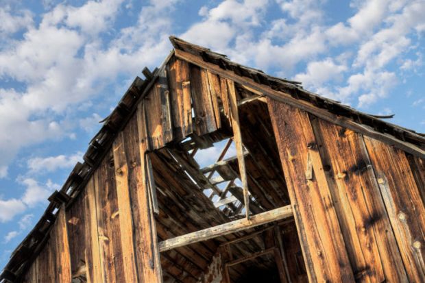 Derelict barn against cloudy blue sky Derelict barn against cloudy blue sky