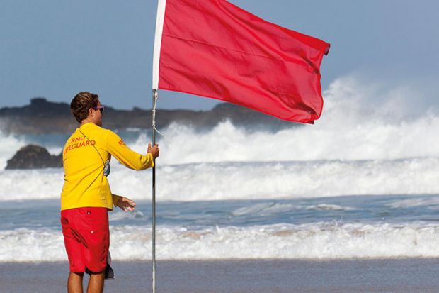 Man holding red flag on beach Man holding red flag on beach