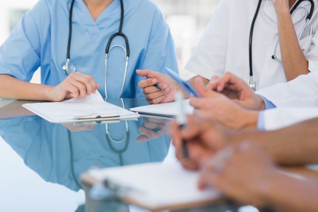 Doctors in a meeting symbolising disagreements about healthcare education