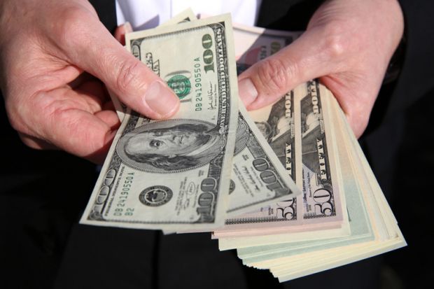 A person holding US dollars A person holding US dollars