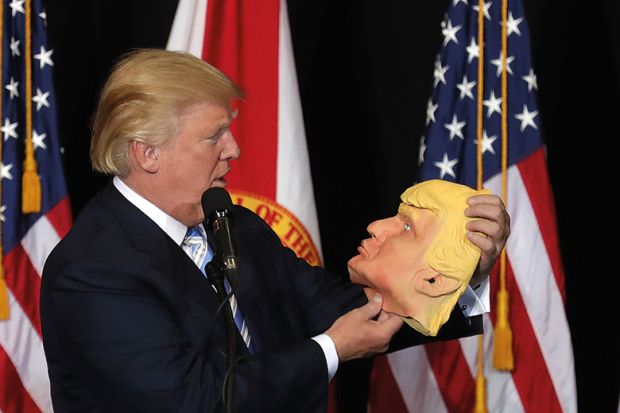 Donald Trump holding mask of his own face Donald Trump holding mask of his own face