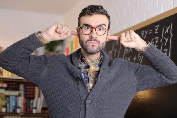 A lecturer puts his fingers in his ears, illustrating a resual to reflect