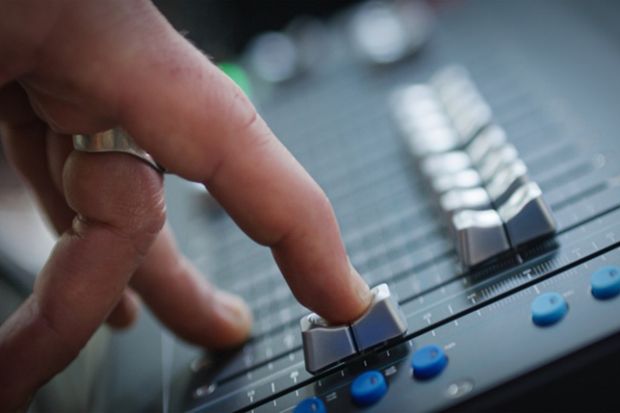 A finger slides down a fader on a mixing desk A finger slides down a fader on a mixing desk, illustrating the fading out of music scholarship