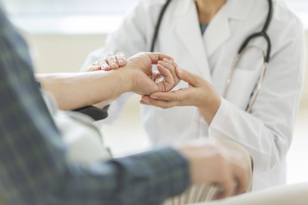 Female doctor and senior man illustrating news article about increase in admissions of women to Japanese medical schools