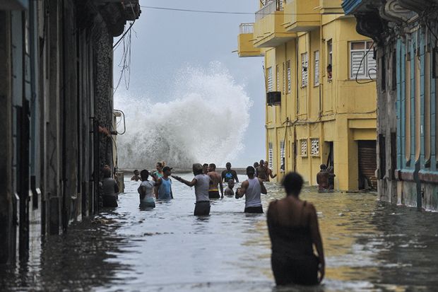 Cubans wade through a flooded street in Havana after Hurricane Irma swept through the country in 2017