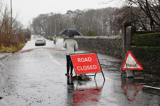 A sign before a flooded road says 'Road closed' A sign before a flooded road says 'Road closed'