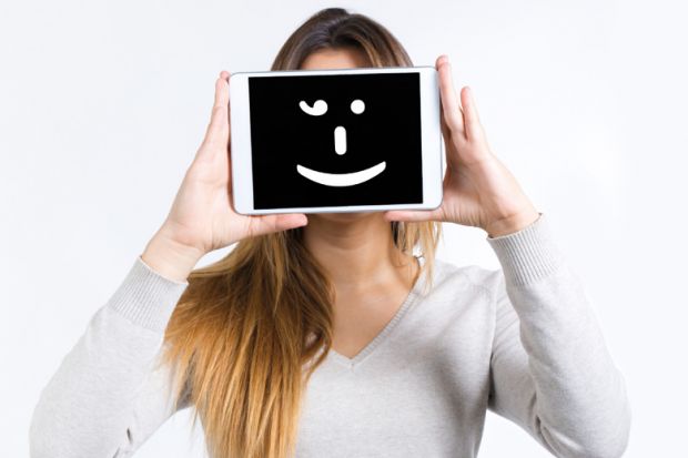 Girl holding a tablet computer with a smiley face on it Girl holding a tablet computer with a smiley face on it