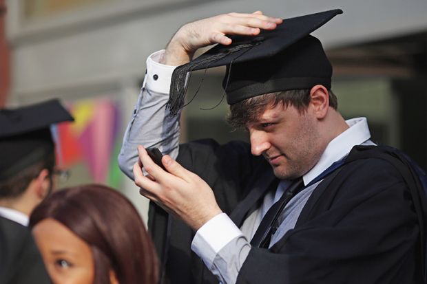 Students adjust their caps ahead of their graduation ceremony, London, UK. To illustrate that over half of graduates regret their undergraduate decisions Students adjust their caps ahead of their graduation ceremony, London, UK. To illustrate that over half of graduates regret their undergraduate decisions